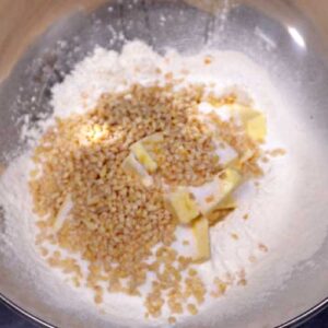 gehackte Mandeln und Zucker zum Mehl gegeben