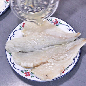 Zitronensaft auf Fisch geben