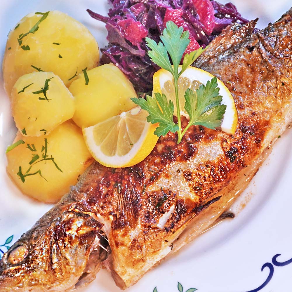 Wolfsbarsch im Ganzen mit Kartoffeln und Rotkohl